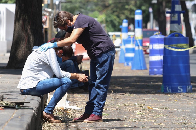 Familiares de pacientes por COVID-19 rompen en llanto mientras ambulancias y carros funerarios entran y salen del Hospital.