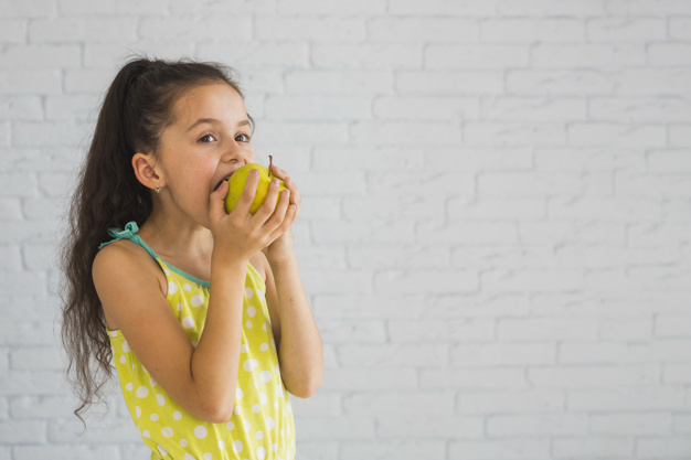 niña comiendo fruta