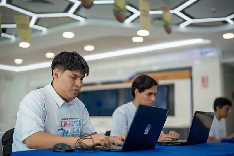 Estudiantes participando en un taller de tecnología, trabajando en laptops en un ambiente de capacitación.
