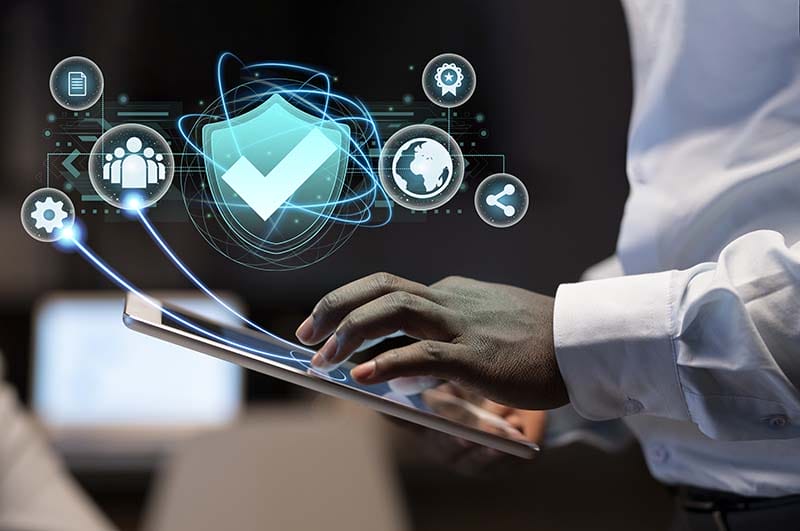 Una persona utilizando una tablet con gráficos digitales que representan conceptos de seguridad, comunicación y tecnología.