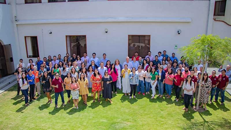 Gran grupo de empleados de El Británico posando en un espacio verde al aire libre, celebrando su reconocimiento como un excelente lugar para trabajar.