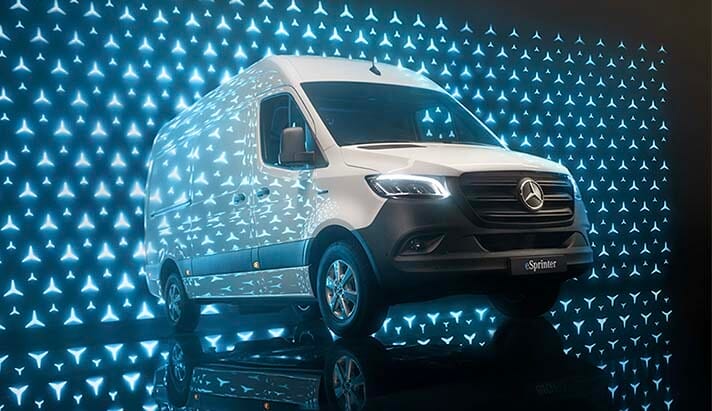 Furgoneta Mercedes-Benz Sprinter en un fondo con luces brillantes, destacando su diseño moderno y características tecnológicas.