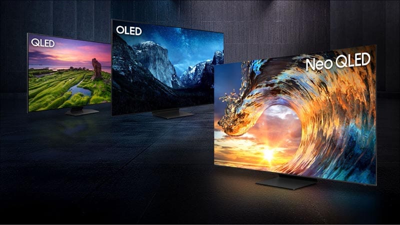 Tres televisores en pantalla: un modelo QLED, uno OLED y un modelo Neo QLED, mostrando diferentes imágenes vibrantes en un entorno oscuro.