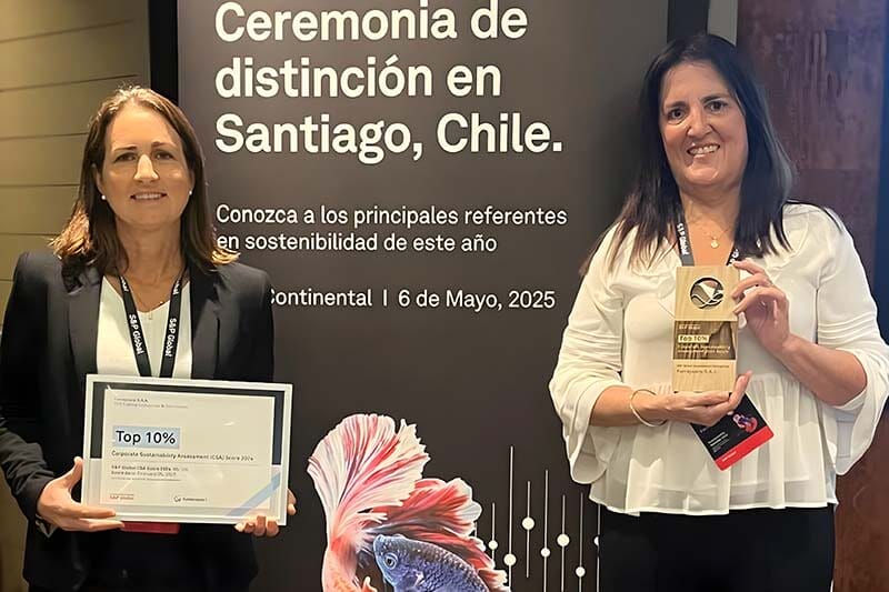 Ceremonia de distinción en Santiago, Chile, donde dos representantes de Ferreycorp muestran sus premios por estar en el Top 10% de empresas más sostenibles, con un cartel detrás que celebra el evento.