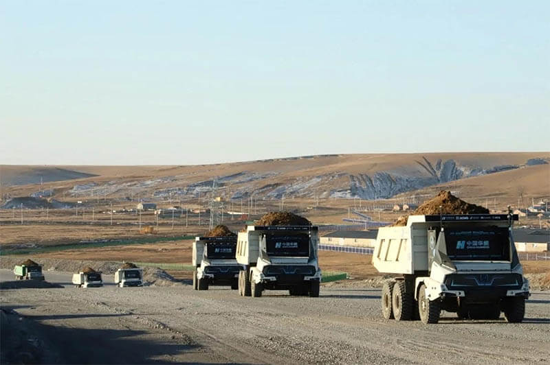 Flota de camiones mineros eléctricos autónomos operando en una mina en Mongolia Interior.