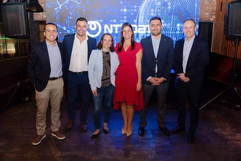 Grupo de seis profesionales posando frente a un fondo con el logo de NTT DATA, en el evento 'Seguridad Inteligente en un mundo conectado' en Lima.