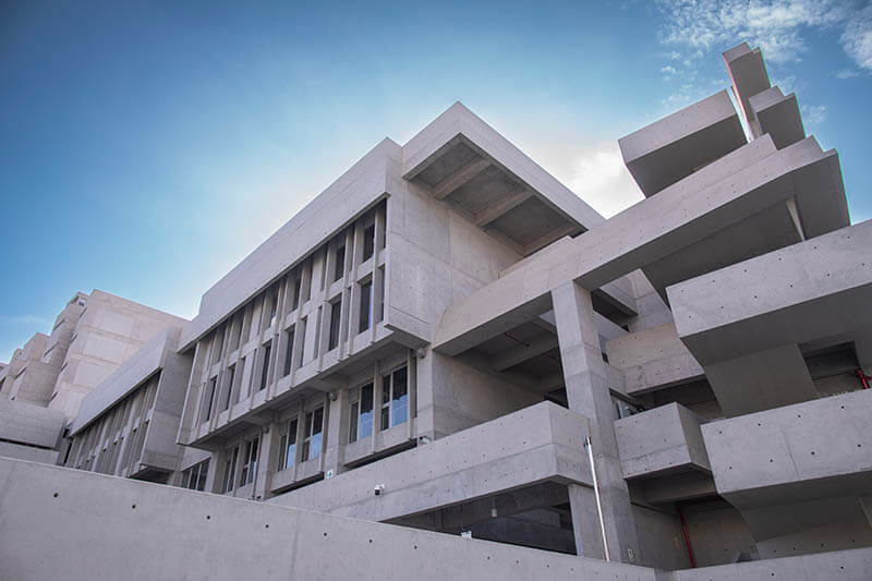 Vista exterior del nuevo edificio de la Universidad de Ingeniería y Tecnología (UTEC), destacando su arquitectura moderna con concreto expuesto y amplias ventanas.