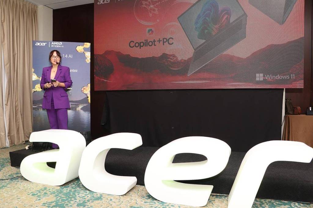 Presentadora de Acer en un evento mostrando la nueva laptop Swift AI con procesador AMD Ryzen 9 365, frente a una pantalla que destaca las características del producto.