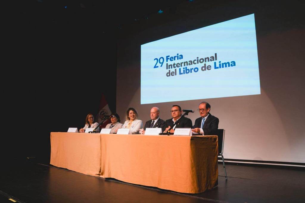 Conferencia de prensa de la 29ª Feria Internacional del Libro de Lima, con varios ponentes sentados en una mesa y una pantalla de fondo que muestra el logo del evento.