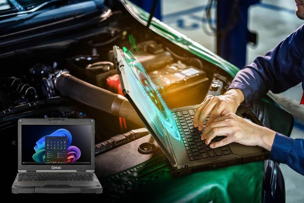 Un técnico utiliza la notebook Getac B360 Plus en el capó de un vehículo, mostrando su diseño robusto y pantalla funcional en un entorno de trabajo desafiante.