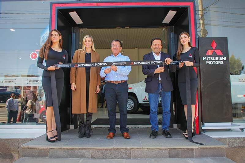 Inauguración de la nueva tienda Mitsubishi Motors en Arequipa, con representantes sosteniendo la cinta ceremonial frente a la entrada.