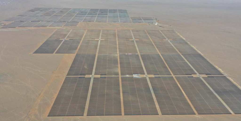 Vista aérea de la planta solar San Martín en La Joya, Arequipa, mostrando múltiples filas de paneles solares en un desierto.
