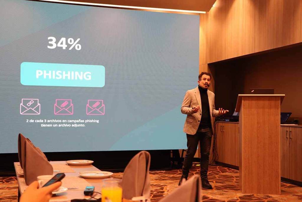 Presentación sobre ciberseguridad en el evento ESET Security Days 2025, destacando un gráfico que indica que el 34% de las amenazas son phishing, con el ponente explicando que 2 de cada 3 campañas de phishing incluyen archivos adjuntos.