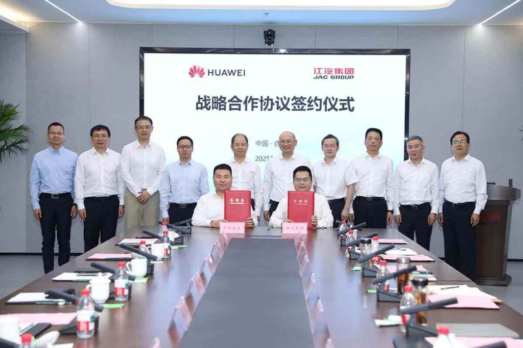 Ceremonia de firma de alianza estratégica entre JAC Group y Huawei Technologies, con representantes de ambas empresas en una sala de reuniones.