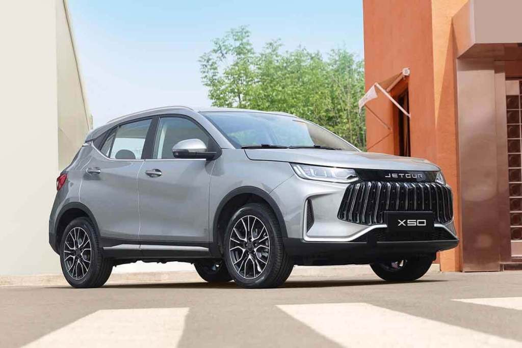 SUV Jetour X50 en un entorno urbano, mostrando diseño exterior compacto y elegante, con un acabado plateado y detalles en negro.