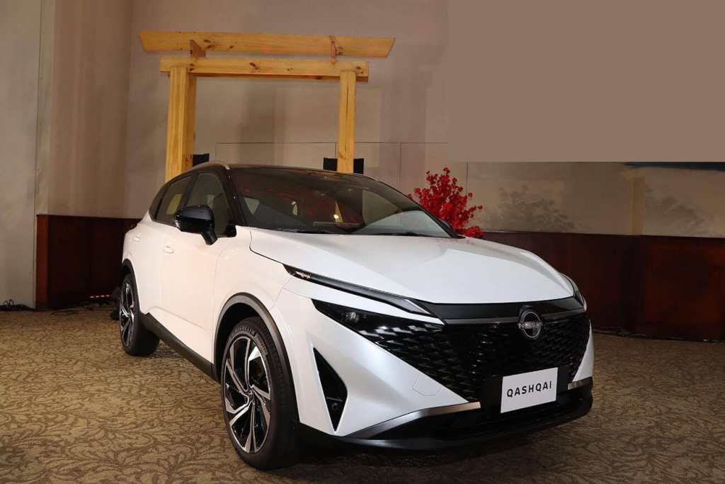 La nueva Nissan Qashqai 2025 en color blanco, exhibida en un evento, con un diseño exterior moderno que destaca su parrilla diamantada y faros LED remodelados.
