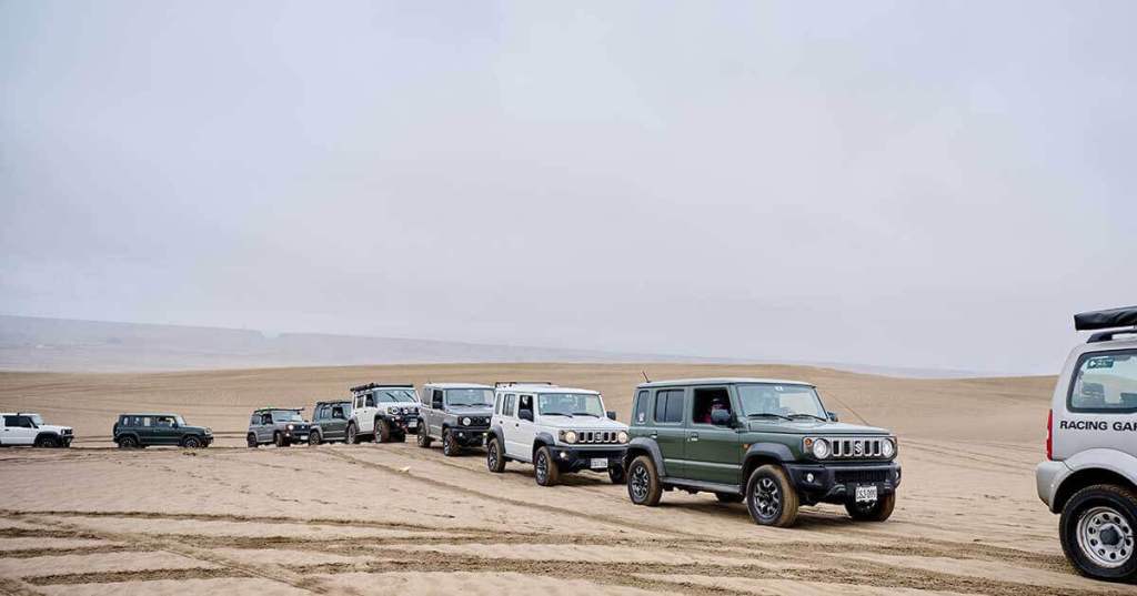 Varias camionetas Suzuki Jimny alineadas en las dunas de Sarapampa durante el evento 'Jimny Experience'.