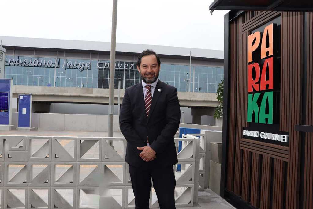 Retrato de un hombre de pie frente al restaurante Paraka, con la letrero visible y el nuevo terminal del Aeropuerto Internacional Jorge Chávez al fondo.