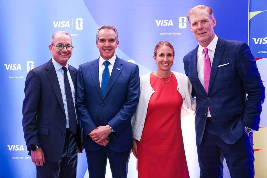 Cuatro personas posando juntas en un evento, con fondo azul y logotipos de Visa, en un contexto relacionado con la Copa Mundial de la FIFA 2026.
