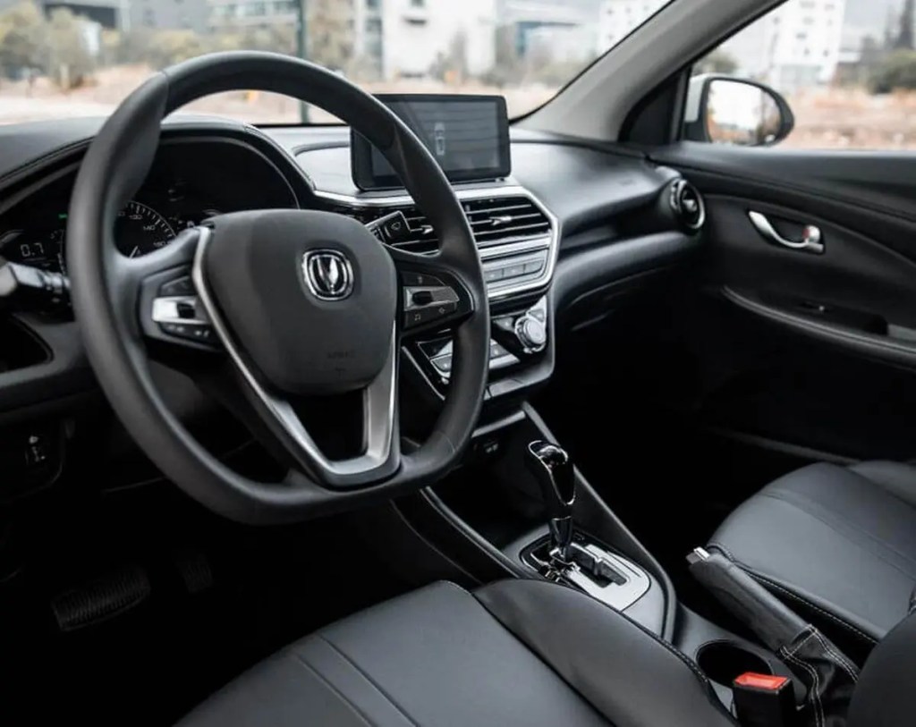 Interior de un sedán Changan Alsvin, con volante y consola central mostrando controles y pantalla digital.