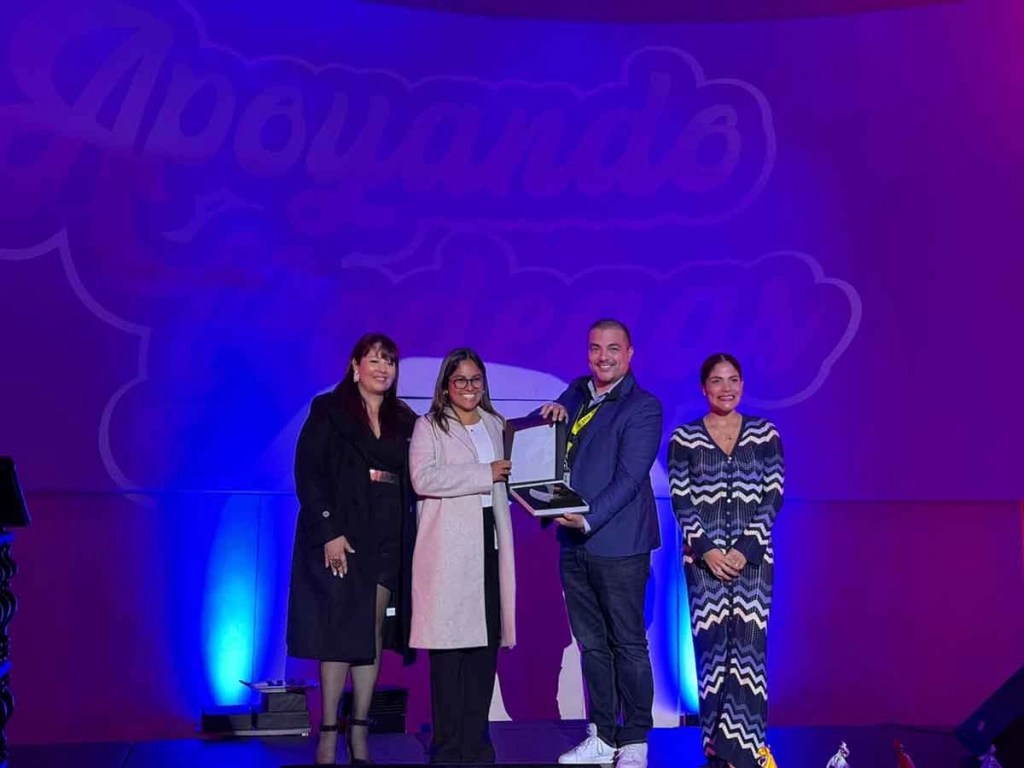 Entrega de premio durante la ceremonia 'Apoyando Bodegas', con cuatro personas posando en el escenario.