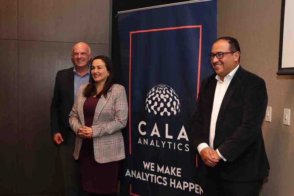 Tres personas sonriendo junto a un banner de CALA Analytics que dice 'WE MAKE ANALYTICS HAPPEN'.