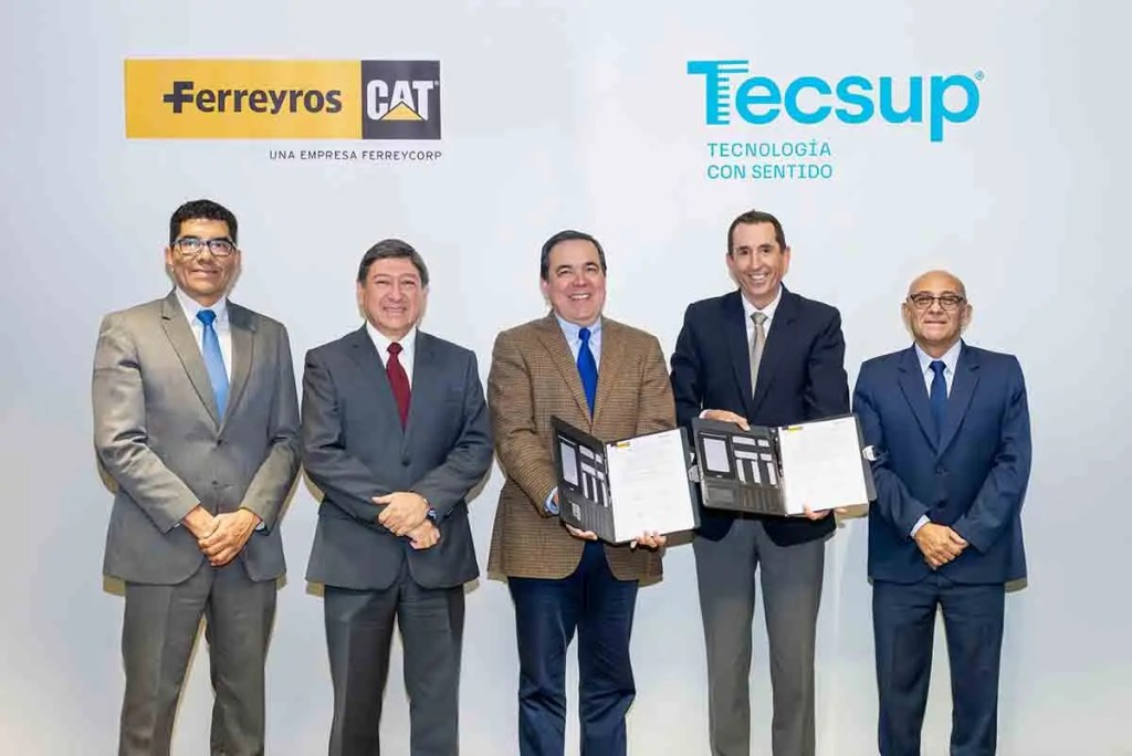 Representantes de Ferreyros y Tecsup posan juntos tras la firma de un convenido de cooperación interinstitucional, con documentos en manos, en un ambiente profesional.