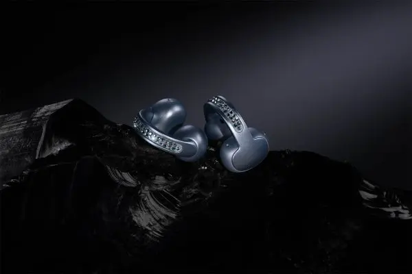Vista de los earbuds moto buds loop, adornados con cristales Swarovski, sobre un fondo oscuro y texturizado, resaltando su diseño elegante y moderno.