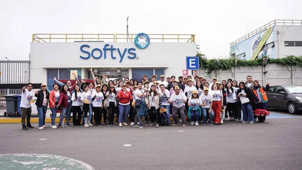 Grupo de personas frente a la sede de Softys en Perú, celebrando un evento con camisetas temáticas y sonrisas.