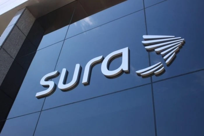 Logo de SURA en la fachada de un edificio, en un entorno empresarial.