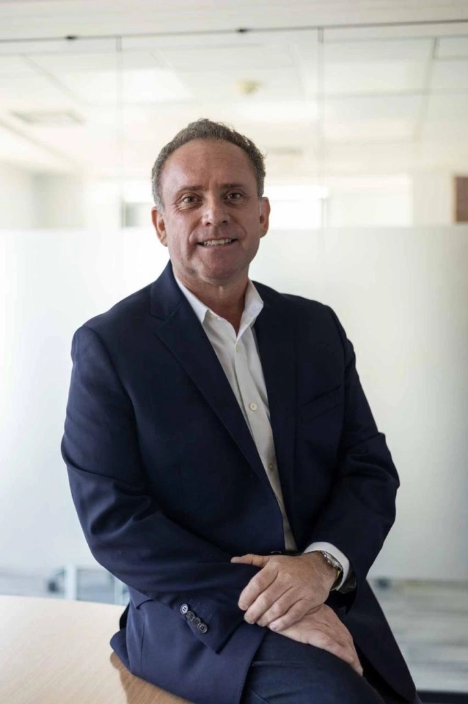 Retrato de Alejandro Donoso Henríquez, Director de Stakeholders Management y Comunicaciones para Latinoamérica, sentado en una oficina, vistiendo un traje oscuro y una camisa blanca.