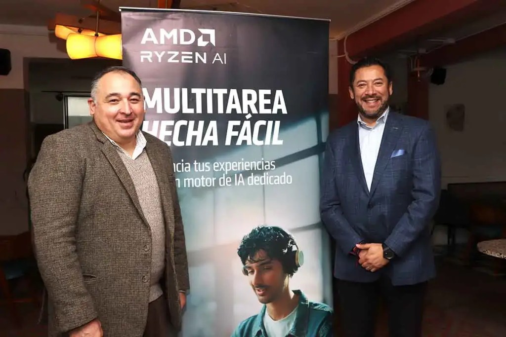 Dos hombres posan junto a un banner de AMD Ryzen AI que resalta el tema de la multitarea y la inteligencia artificial en la vida diaria.
