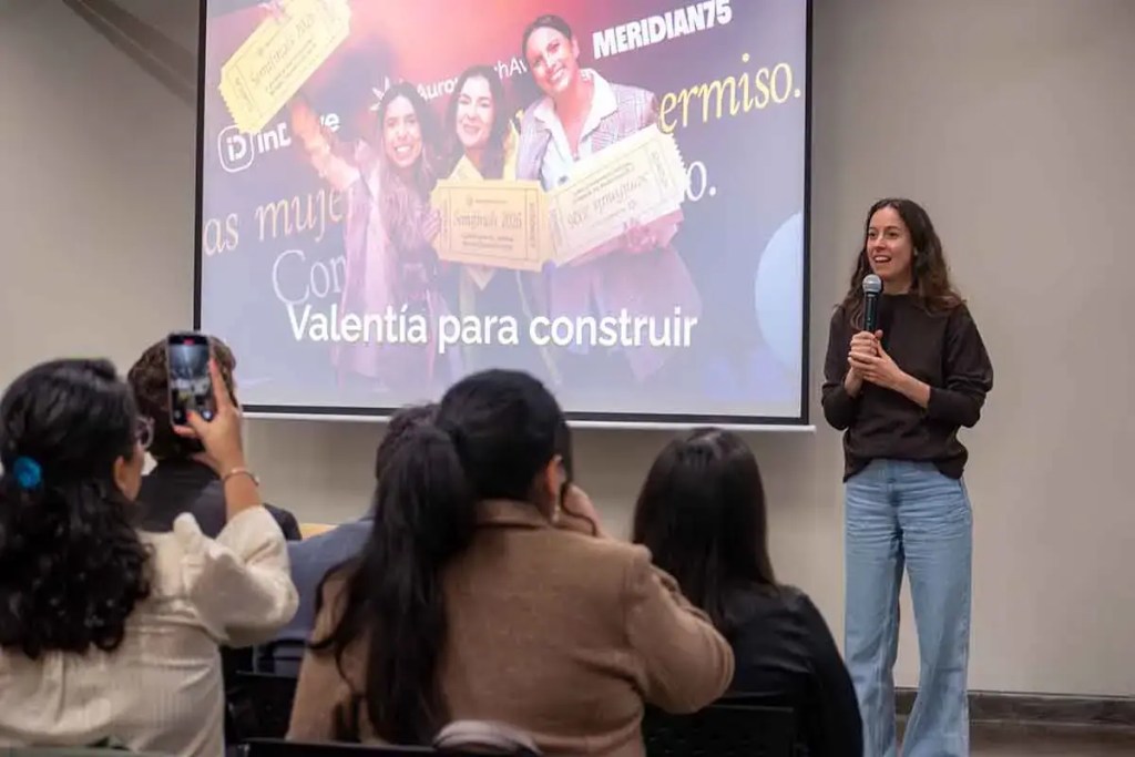 Evento de lanzamiento del Aurora Tech Award 2026, con una oradora frente a un público y una proyección que destaca el lema 'Valentía para construir'.