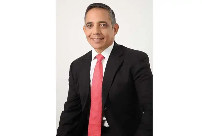 Eduardo Catter, nuevo CEO de SUMTEC, posando con traje y corbata roja, sonriente frente a fondo blanco.