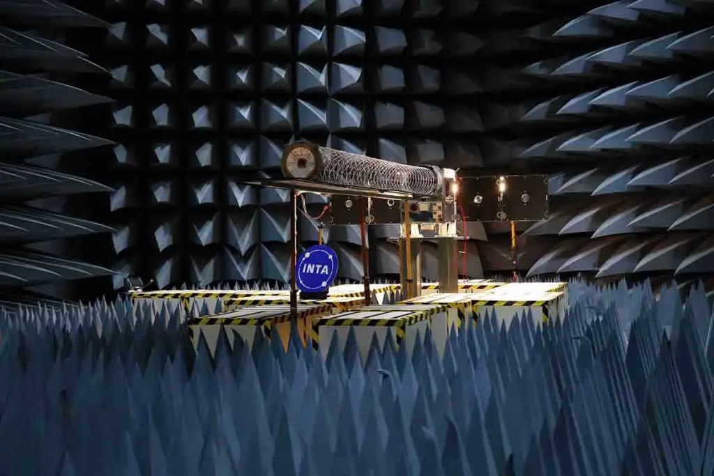 Interior de un laboratorio de pruebas de radiofrecuencia, con un amplificador VHF de alta potencia y equipo relacionado, diseñado para pruebas de comunicación satelital.