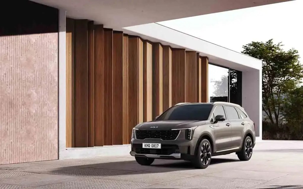 SUV moderno estacionado frente a una estructura arquitectónica elegante con paredes de madera.