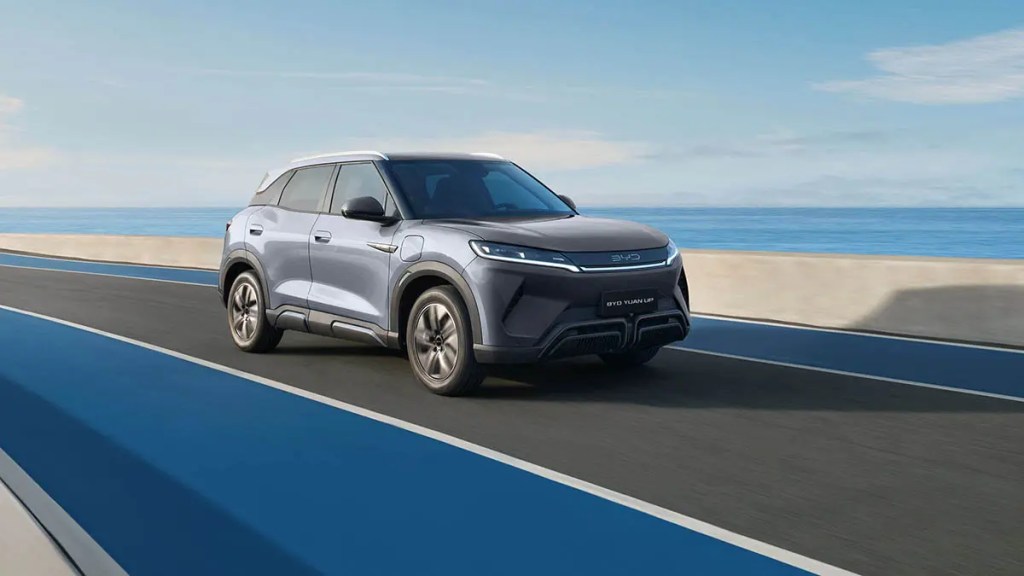 SUV eléctrico de BYD en una carretera frente al mar, destacando su diseño moderno y aerodinámico.