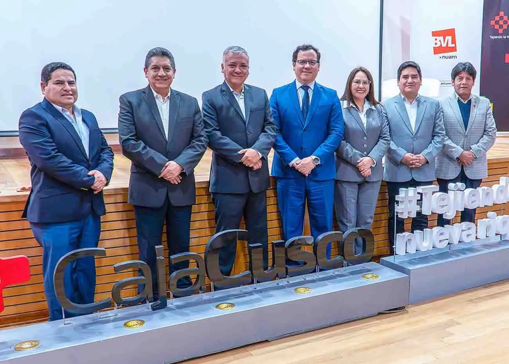 Grupo de líderes del mercado de capitales posando en el evento SUMMIT 2025 en Cusco, con el logo de Caja Cusco en primer plano.