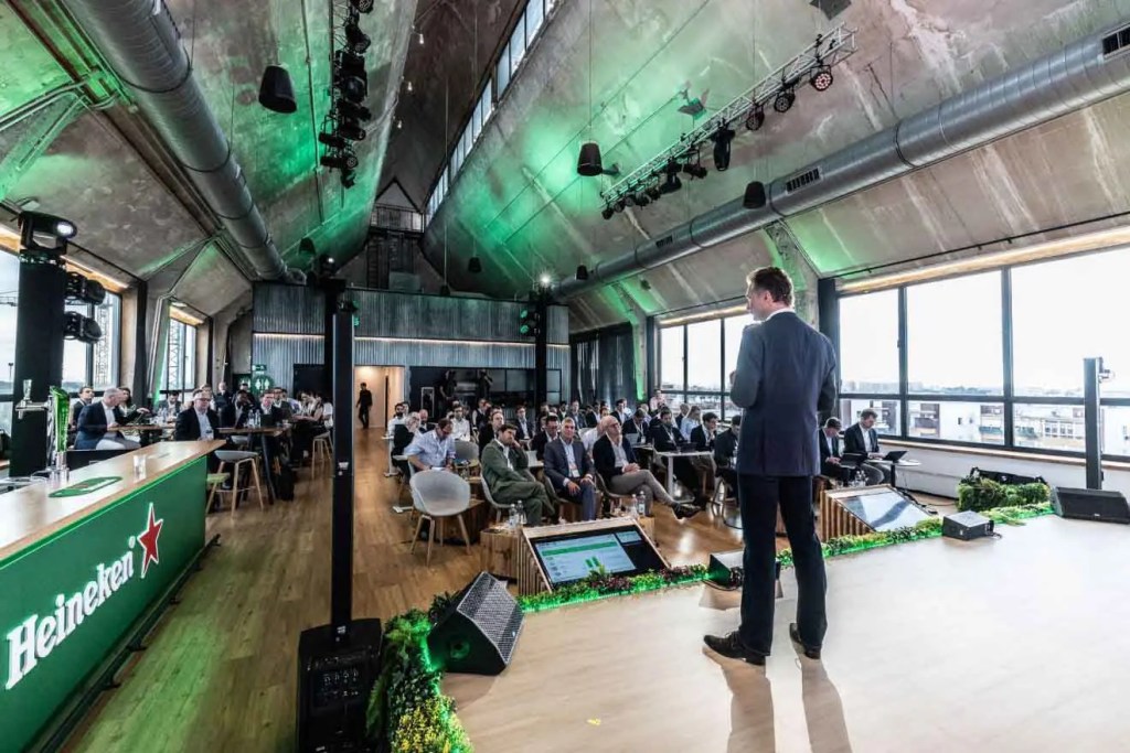 Presentación de la estrategia global EverGreen 2030 de HEINEKEN en un evento con público en un espacio moderno.