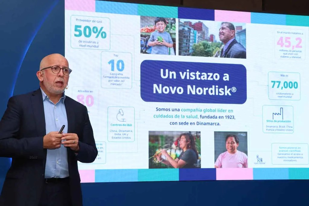 Presentador hablando frente a una pantalla que muestra información sobre Novo Nordisk, incluida su posición en el mercado de insulina y datos sobre diabetes en Perú.