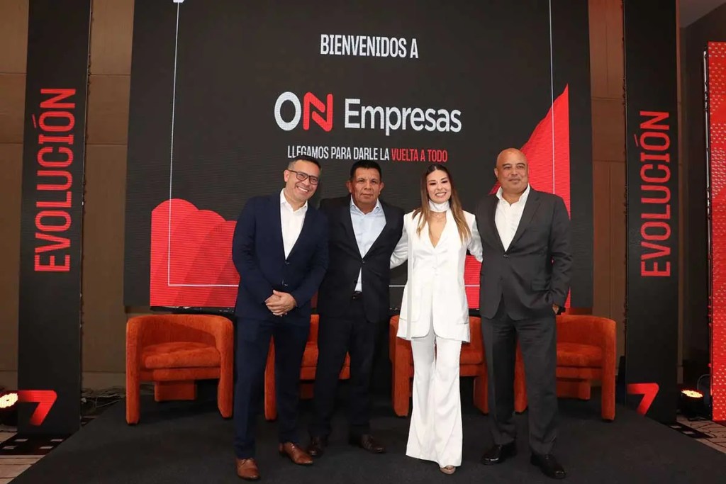 Evento de presentación de ON Empresas con cuatro personas de pie frente a una pantalla que muestra el nuevo logo. Se observa un ambiente profesional y moderno.