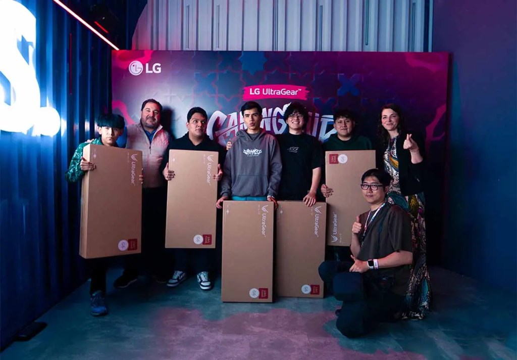 Grupo de seis personas posando en un evento de gaming, sosteniendo cajas de monitores LG UltraGear, con un fondo decorado y un logo de LG visible.