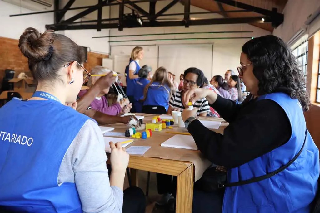 Voluntarios de Samsung en una actividad comunitaria, participando en talleres con adultos mayores y niños, fomentando la inclusión y el aprendizaje intergeneracional.