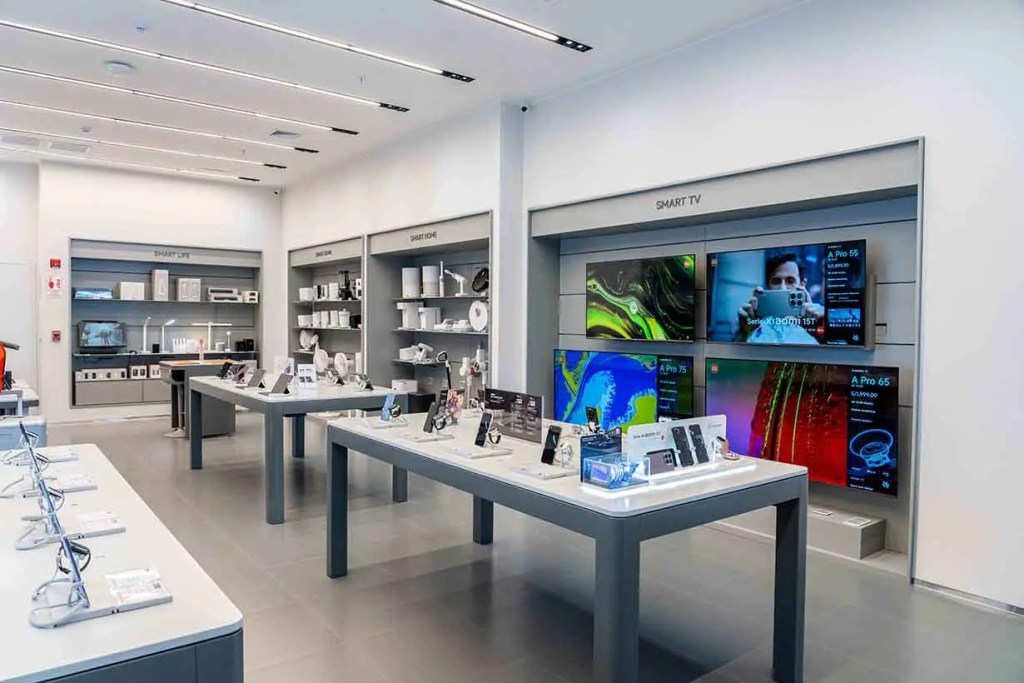 Interior de la tienda Xiaomi renovada, mostrando una variedad de productos como smartphones, dispositivos inteligentes y televisores en un ambiente moderno.