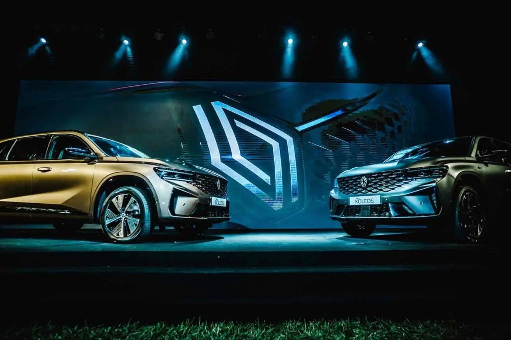 Presentación del nuevo Renault Koleos, una SUV con un diseño innovador, mostrando dos versiones del vehículo en un evento, con un fondo destaca tecnología avanzada.