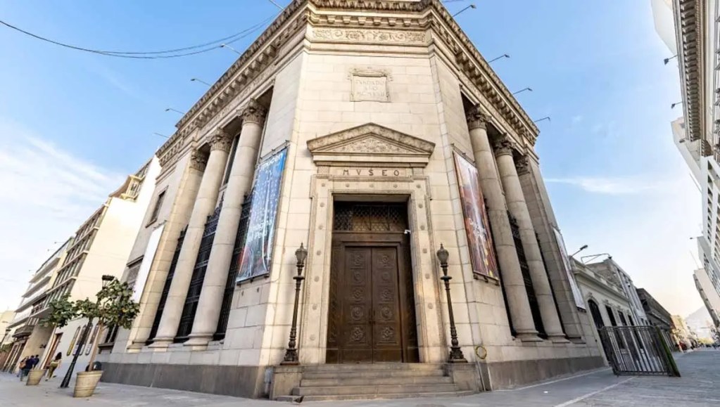 Fachada del museo con columnas y puerta principal en un entorno urbano.