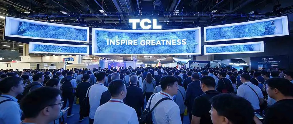 Multitud de asistentes en el CES 2026 frente al stand de TCL, que presenta un gran cartel que dice 'INSPIRE GREATNESS'.