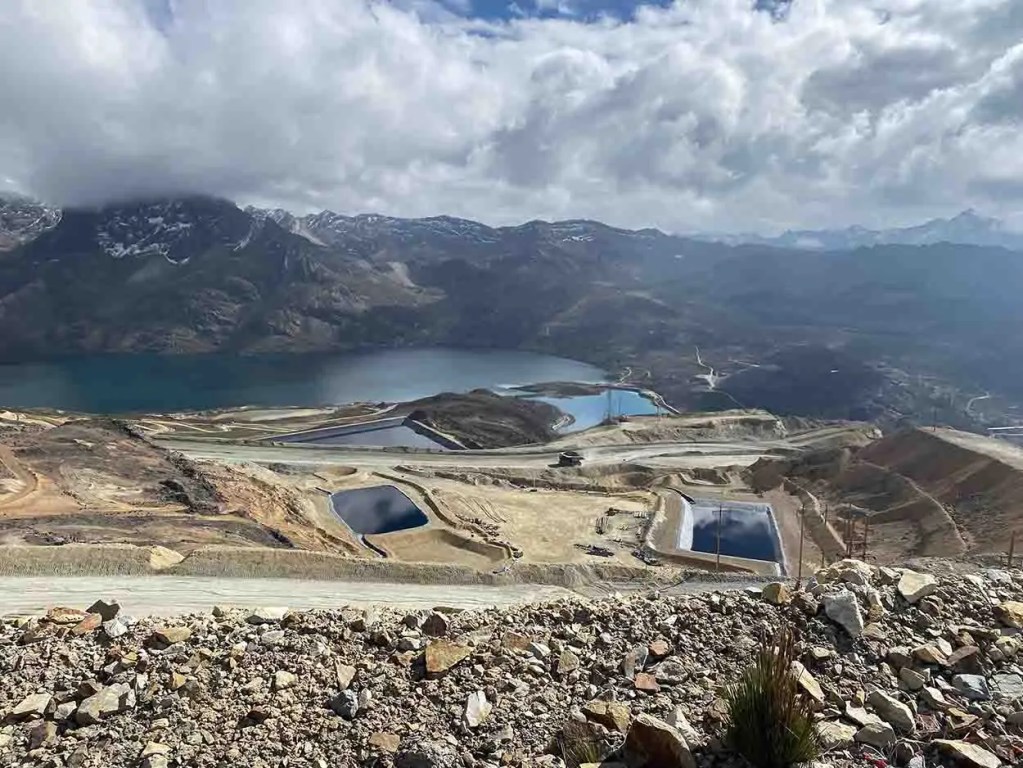 Vista panorámica de la Unidad Minera Toromocho en Junín, Perú, con lagos y montañas al fondo, resaltando el entorno natural y la infraestructura minera.