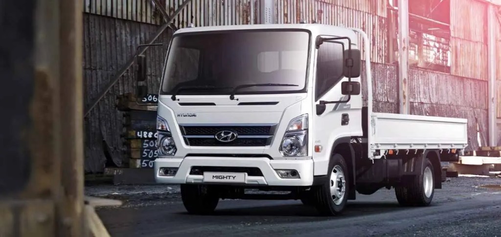 Camión Hyundai Mighty blanco estacionado en un entorno industrial, mostrando su diseño robusto y funcional.