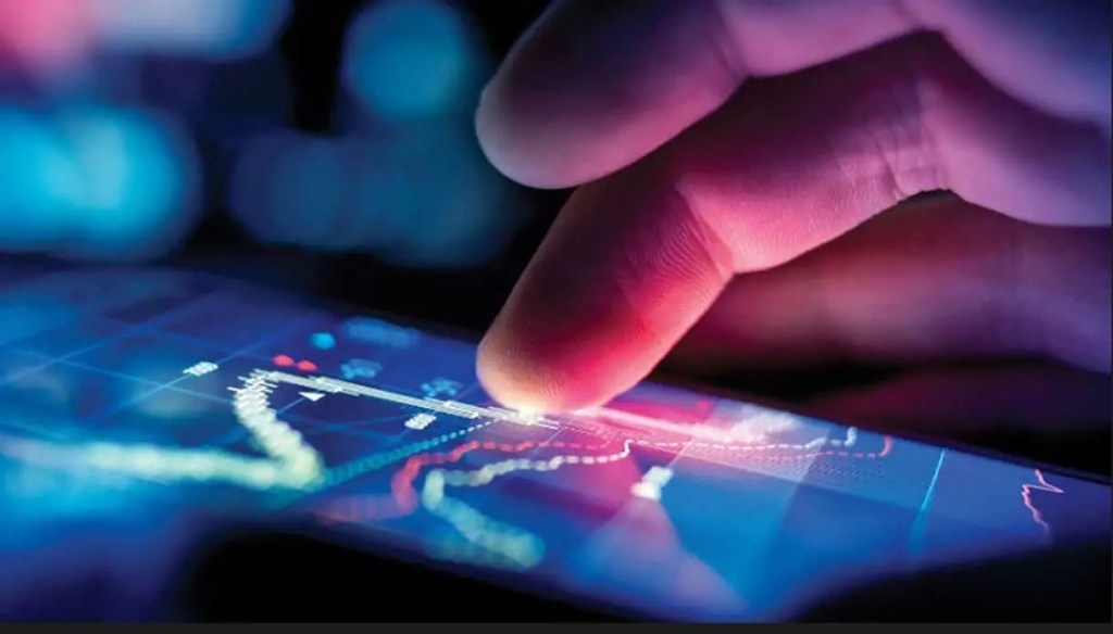 Una mano tocando la pantalla de un dispositivo móvil que muestra gráficos y datos financieros